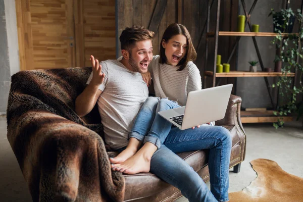 Couple qui s'amuse en découvrant les pronostics de ses amis